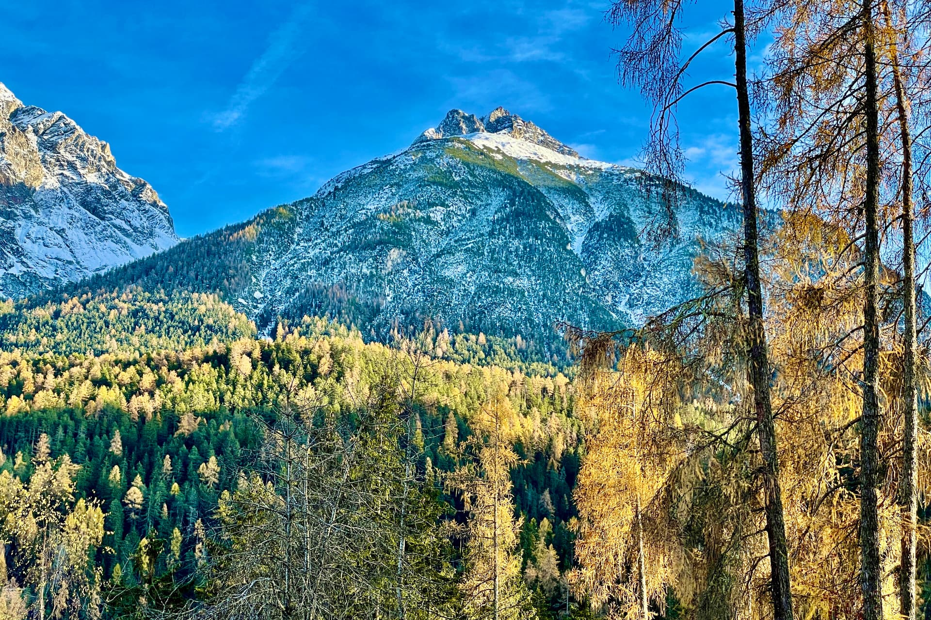 Schneebedeckter Gipfel im Herbstlicht