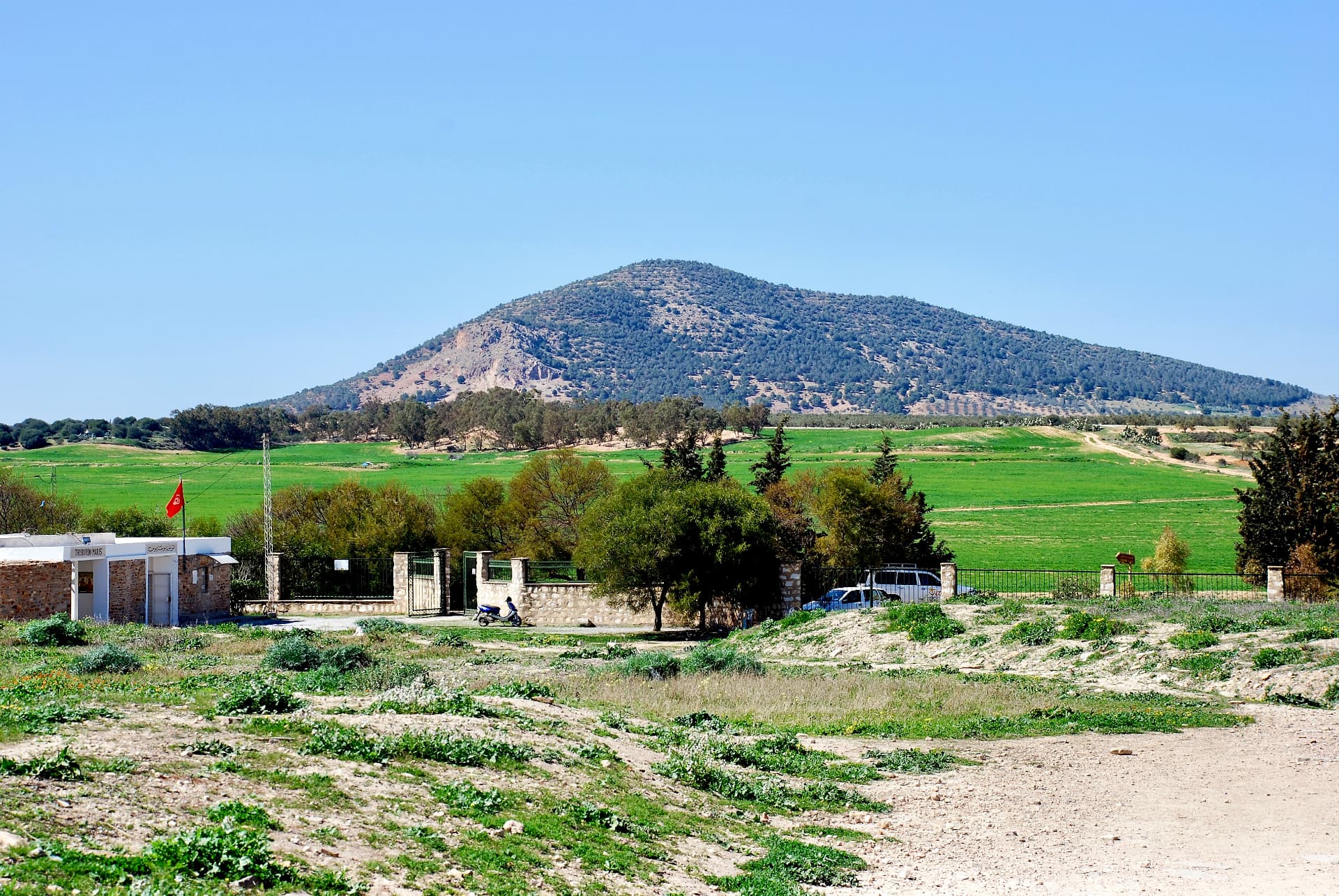 Eingang des archäologischen Parks vor grüner Hügellandschaft