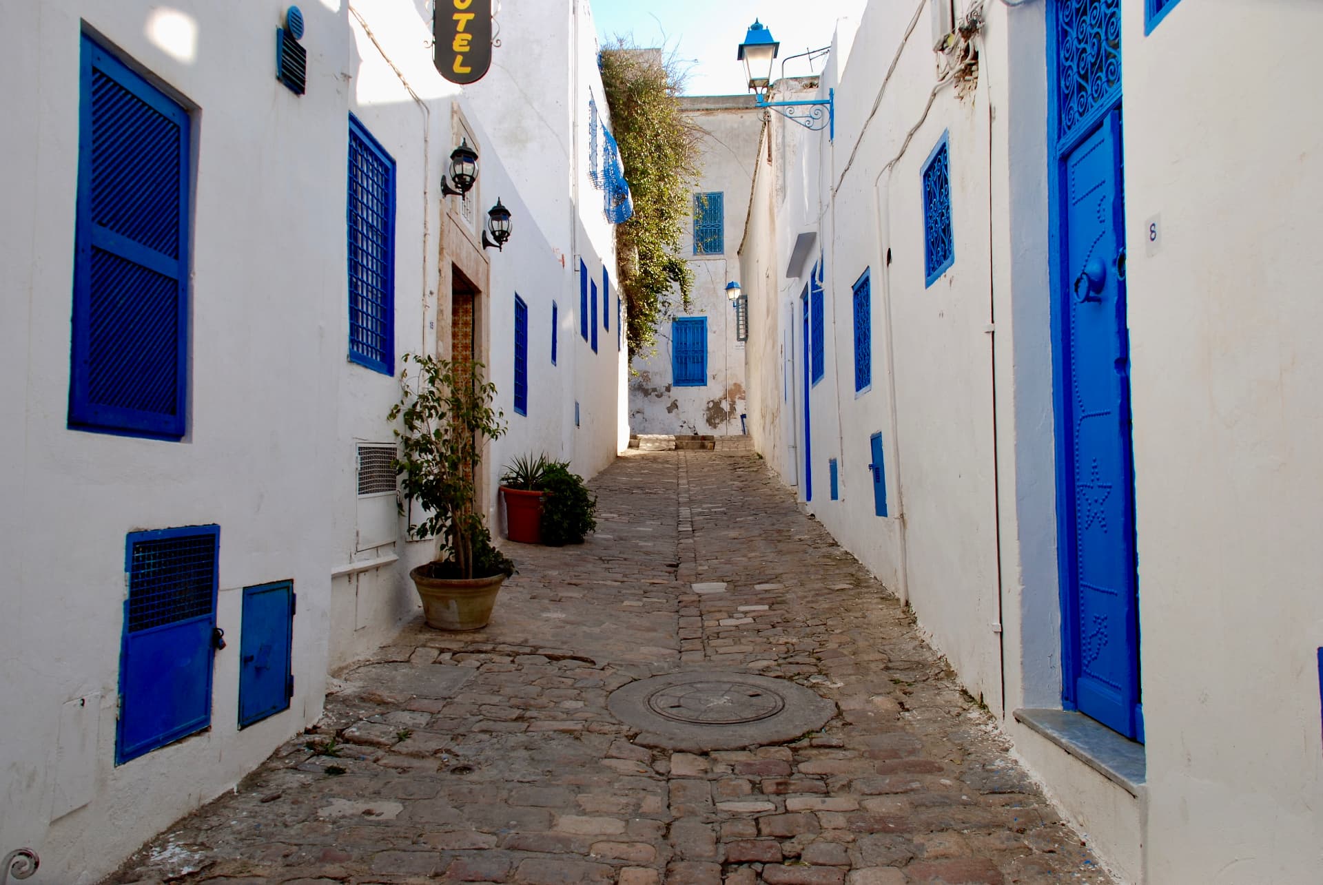 Gasse mit blauem Gitterfenster und Laterne