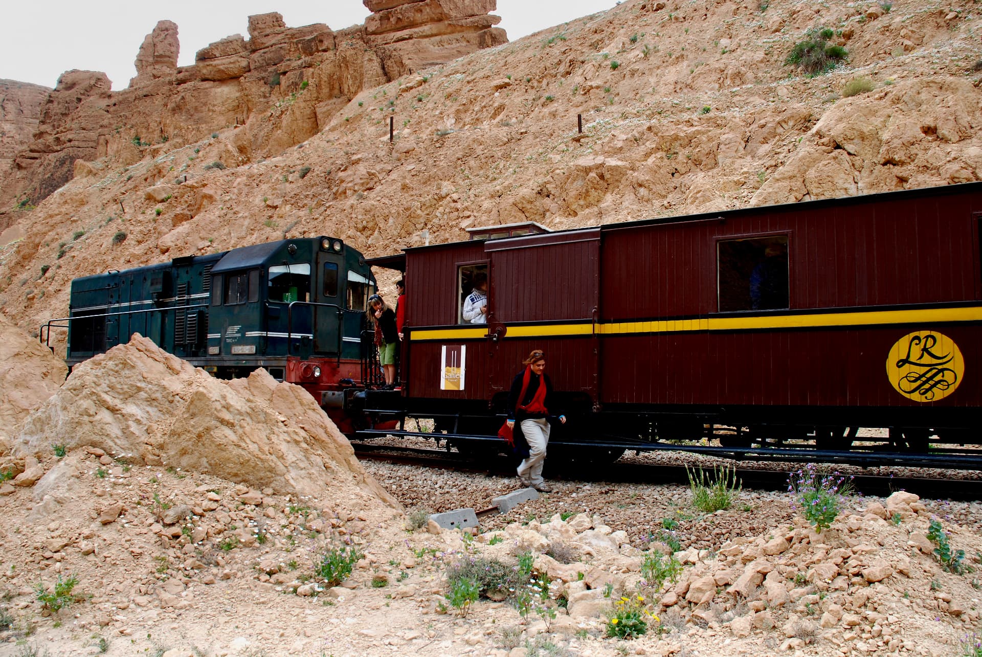 Der Train rouge mit grüner Diesellok und historischem Holzwaggon