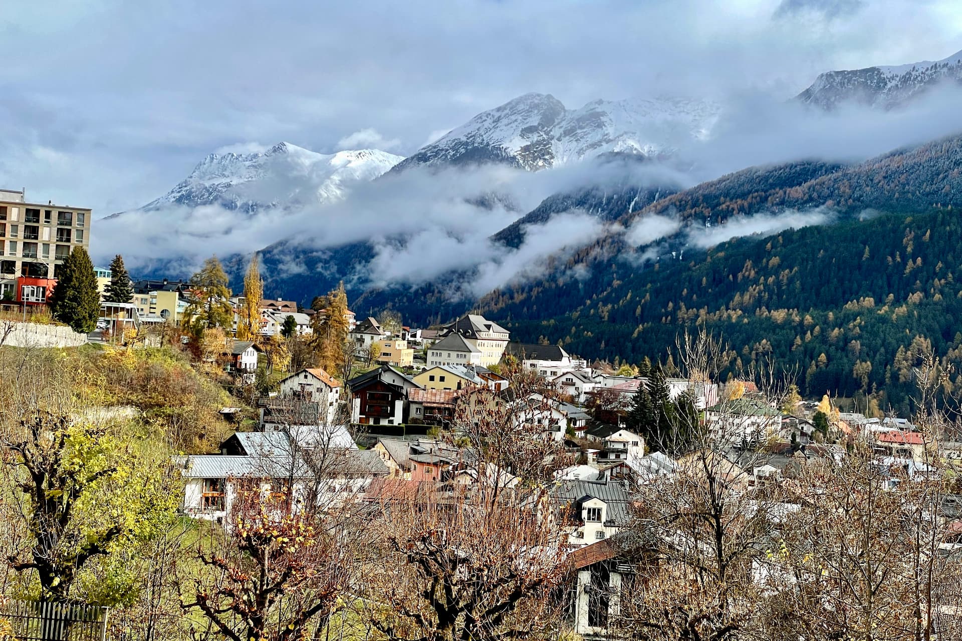 Scuol im Herbst mit Wolken über den Bergen