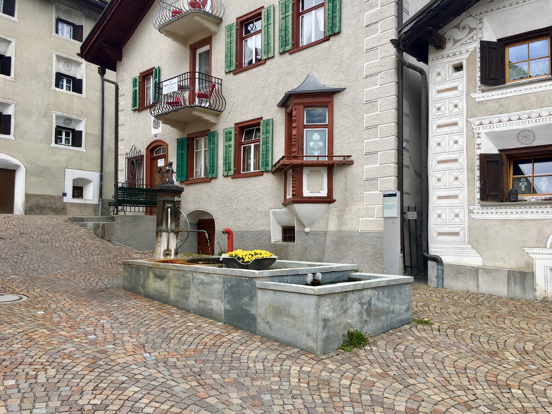 Brunnenplatz zwischen reich verzierten Hausfassaden