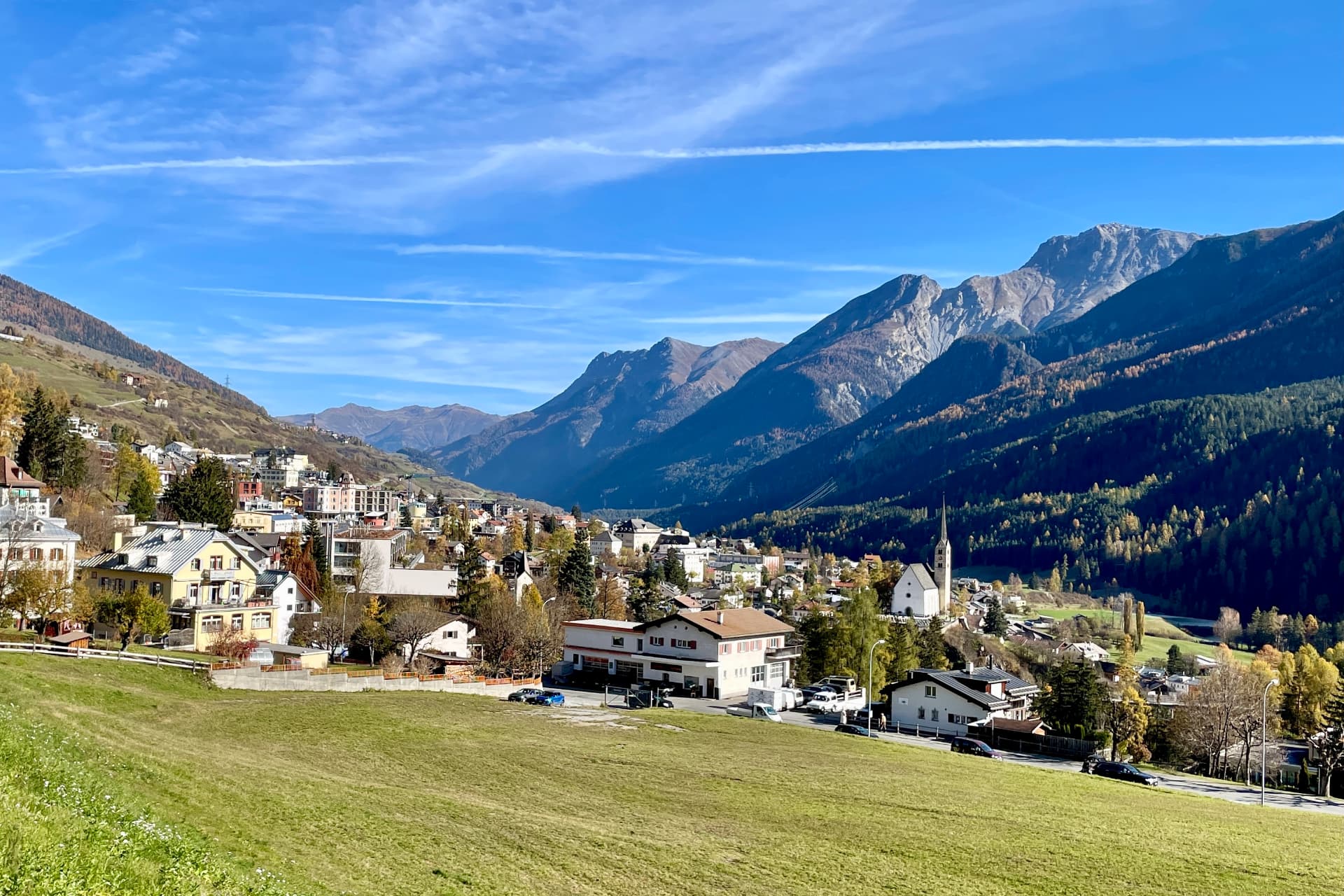 Blick über Scuol im Herbst mit der Kirche über dem Inn
