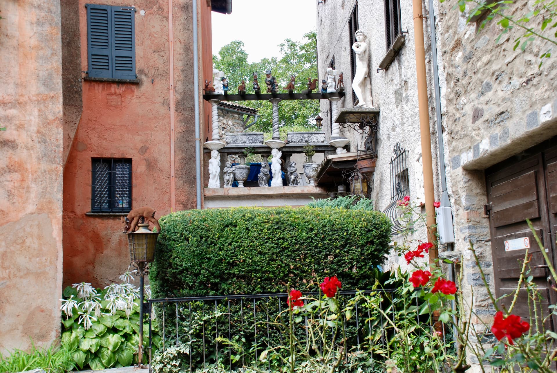 Blumenhof mit Skulpturen und alten Steinmauern
